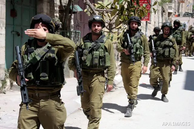 Israeli soldiers stand guard in an empty street in Hebron in the occupied West Bank on April 20, 2011. The Israeli army imposed a temporary curfew on Palestinians in the city centre to allow Jewish settlers to visit the...