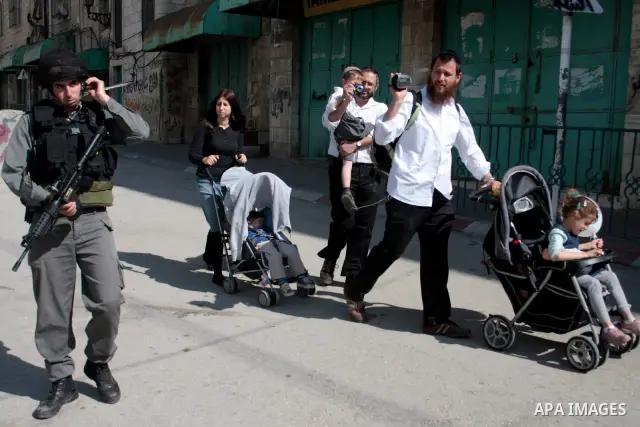 Israeli soldiers stand guard in an empty street in Hebron in the occupied West Bank on April 20, 2011. The Israeli army imposed a temporary curfew on Palestinians in the city centre to allow Jewish settlers to visit the...