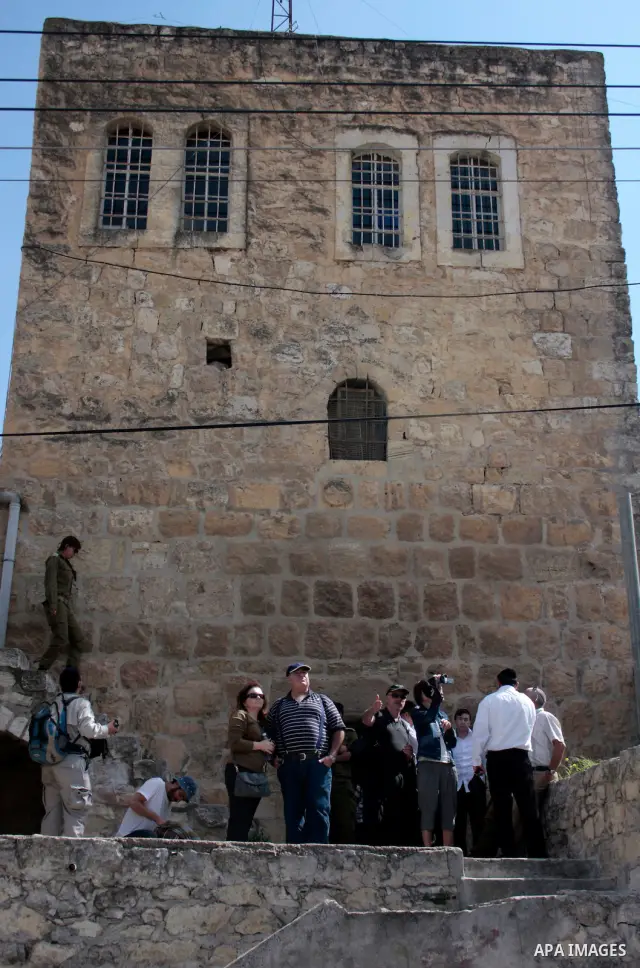 Israeli settlers walk in an empty street in Hebron in the occupied West Bank on April 20, 2011.The Israeli army imposed a temporary curfew on Palestinians in the city centre to allow Jewish settlers to visit the tomb of...