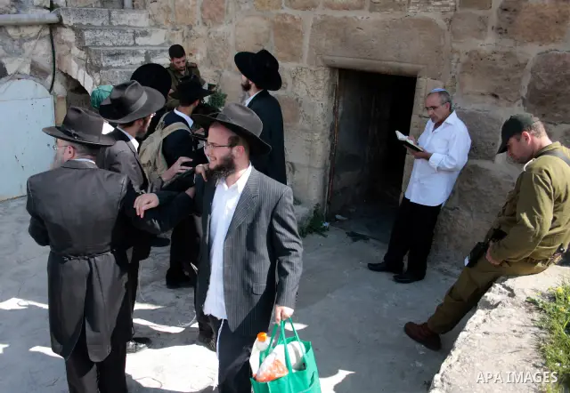 Israeli settlers walk in an empty street in Hebron in the occupied West Bank on April 20, 2011.The Israeli army imposed a temporary curfew on Palestinians in the city centre to allow Jewish settlers to visit the tomb of...