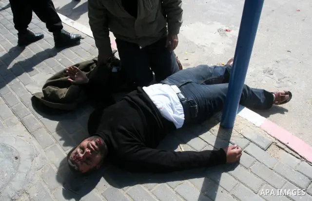 Palestinians gather around an injured man after a tank fired shots toward him in the eastern Gaza city on April 22,2011. Three Palestinians were lightly to moderately wounded when a tank fired at a group of people near t...