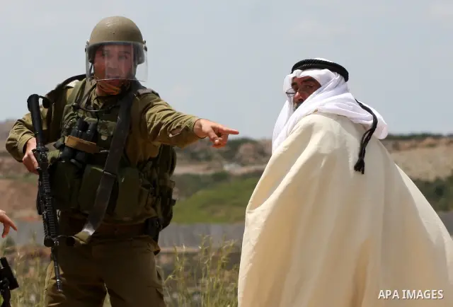 An Israeli soldier scuffles with A Palestinian man during the weekly demonstration against Israel's controversial separation barrier in the village of Bilin, near the West Bank city of Ramallah on April 22, 2011. Some 25...