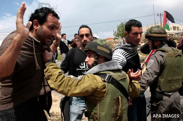 Protesters argue with an Israeli soldier during a demonstration against Israel's controversial separation barrier in the West Bank village of Maasarah, near the biblical town of Bethlehem on April 22, 2011.Israel says th...