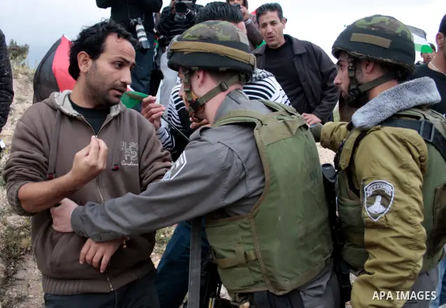Protesters argue with an Israeli soldier during a demonstration against Israel's controversial separation barrier in the West Bank village of Maasarah, near the biblical town of Bethlehem on April 22, 2011.Israel says th...