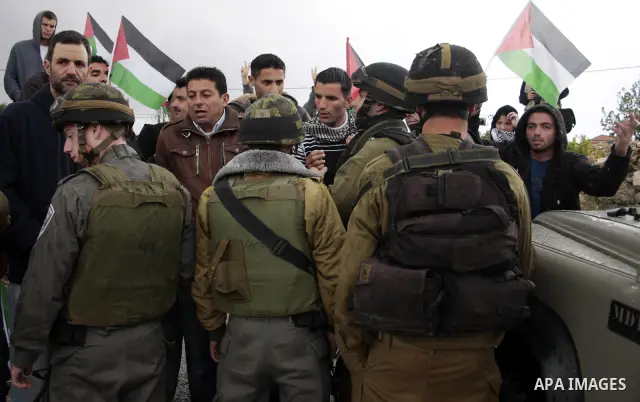 Protesters argue with an Israeli soldier during a demonstration against Israel's controversial separation barrier in the West Bank village of Maasarah, near the biblical town of Bethlehem on April 22, 2011.Israel says th...