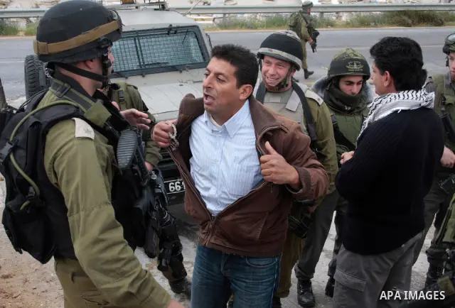 Protesters argue with an Israeli soldier during a demonstration against Israel's controversial separation barrier in the West Bank village of Maasarah, near the biblical town of Bethlehem on April 22, 2011.Israel says th...