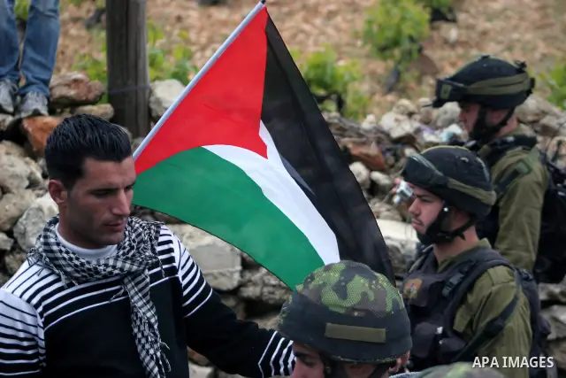 Protesters argue with an Israeli soldier during a demonstration against Israel's controversial separation barrier in the West Bank village of Maasarah, near the biblical town of Bethlehem on April 22, 2011.Israel says th...