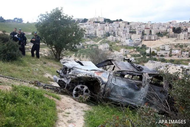 Israeli soldiers stand guard near a burnt Israeli army vehicle on April 22, 2011 after it flipped over and was set alight by Palestinian youths in the flashpoint neighbourhood of Issawiya in annexed east Jerusalem. No in...