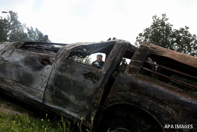 Israeli soldiers stand guard near a burnt Israeli army vehicle on April 22, 2011 after it flipped over and was set alight by Palestinian youths in the flashpoint neighbourhood of Issawiya in annexed east Jerusalem. No in...