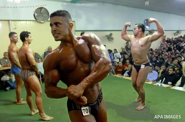 Palestinian men take part during competing in a bodybuilding contest at a hall in Gaza city, Friday, April 22, 2011. Many of the men use women's cosmetics, mud, or paint to enhance their muscles. Number of men from aroun...