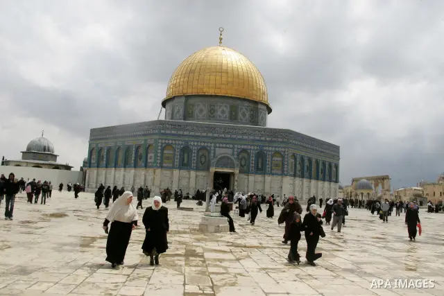 Palestinians walk in front of the Dome of the Rock on the compound known to Muslims as al-Haram al-Sharif, and to Jews as Temple Mount in Jerusalem's Old City April 23, 2011. photo by MAhfouz Abu Turk