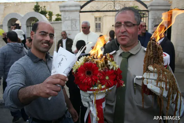 Palestinian Orthodox Christians gather on April 23, 2011, to take part in the 'Holy Fire' parade on the eve of the Orthodox Easter Sunday in the West Bank city of Ramallah in the Israeli occupied West Bank. Photo by Issa...