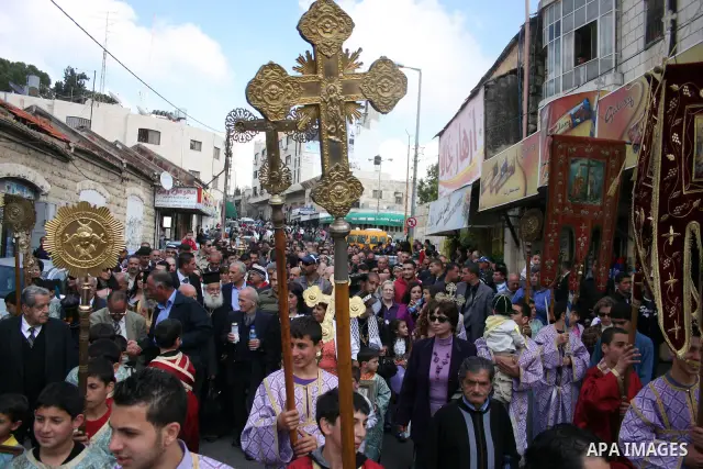 Palestinian Orthodox Christians gather on April 23, 2011, to take part in the 'Holy Fire' parade on the eve of the Orthodox Easter Sunday in the West Bank city of Ramallah in the Israeli occupied West Bank. Photo by Issa...
