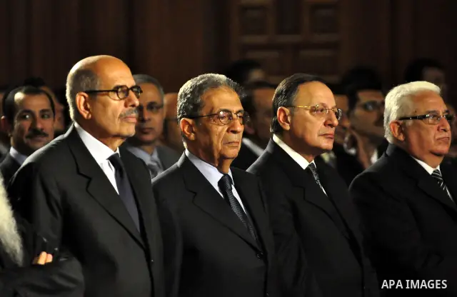 Egypt's presidential candidates Arab League Secretary-General Amr Moussa (R) and Mohamed El Baradei stand next to a priest (L) during a Coptic Christian Easter service at the main cathedral in Cairo April 23, 2011. This...