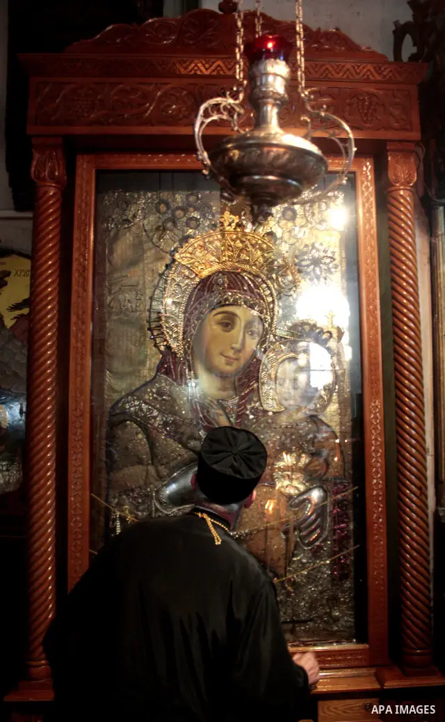 Russian worshippers stand in front of an icon inside the Church of the Nativity in the West Bank town of Bethlehem April 24, 2011.The church is built over the grotto where Christians believe the Virgin Mary gave birth to...