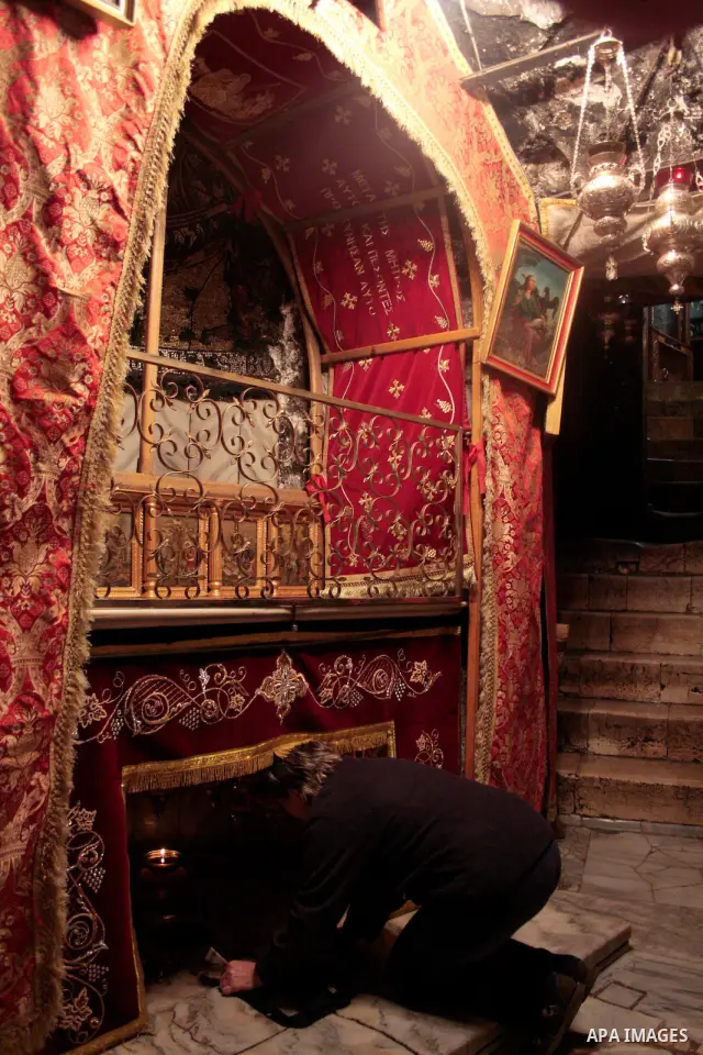 A Christian pilgrim prays in the Grotto, the alleged birthplace of Jesus Christ, in the Church of the Nativity during Sunday mass, April 24 2011.Photo by Najeh Hashlamoun..