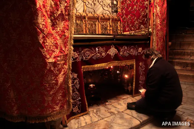 A Christian pilgrim prays in the Grotto, the alleged birthplace of Jesus Christ, in the Church of the Nativity during Sunday mass, April 24 2011.Photo by Najeh Hashlamoun..
