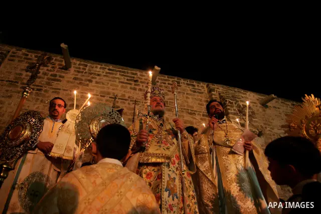 Christian Orthodox hold up candles lit from the 'Holy Fire' as thousands gather in the Church in Gaza City on April 24, 2011. Photo by Mohammed Othman