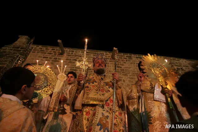 Christian Orthodox hold up candles lit from the 'Holy Fire' as thousands gather in the Church in Gaza City on April 24, 2011. Photo by Mohammed Othman