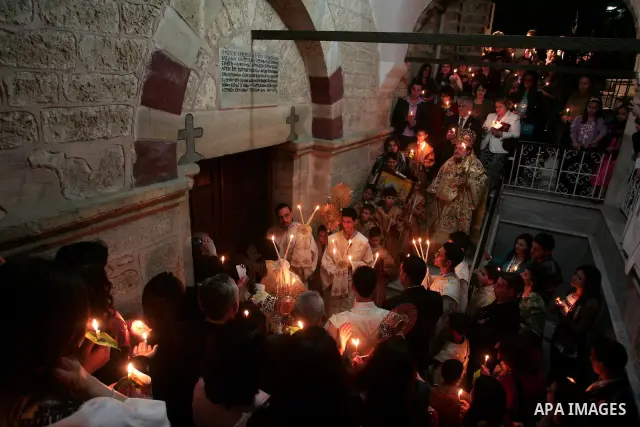 Christian Orthodox hold up candles lit from the 'Holy Fire' as thousands gather in the Church in Gaza City on April 24, 2011. Photo by Mohammed Othman