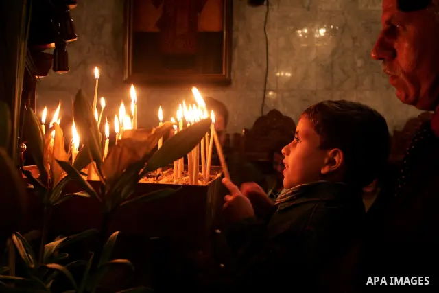 Christian Orthodox hold up candles lit from the 'Holy Fire' as thousands gather in the Church in Gaza City on April 24, 2011. Photo by Mohammed Othman