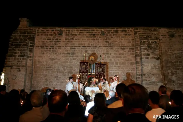 Christian Orthodox hold up candles lit from the 'Holy Fire' as thousands gather in the Church in Gaza City on April 24, 2011. Photo by Mohammed Othman
