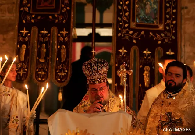 Christian Orthodox hold up candles lit from the 'Holy Fire' as thousands gather in the Church in Gaza City on April 24, 2011. Photo by Mohammed Othman