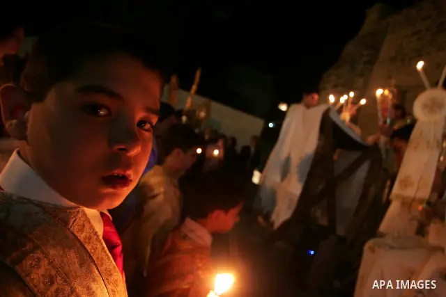Christian Orthodox hold up candles lit from the 'Holy Fire' as thousands gather in the Church in Gaza City on April 24, 2011. Photo by Mohammed Othman