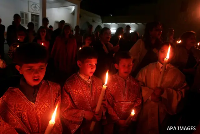 Christian Orthodox hold up candles lit from the 'Holy Fire' as thousands gather in the Church in Gaza City on April 24, 2011. Photo by Mohammed Othman