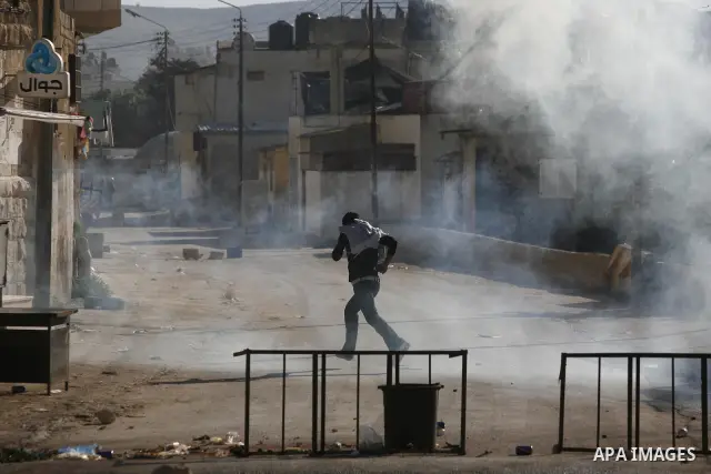 Palestinian youth throw stones towards Israeli soldiers patrolling near the shrine of Joseph's Tomb in the West Bank city of Nablus on April 24, 2011 as clashes erupted after an Israeli worshipper was shot dead by Palest...