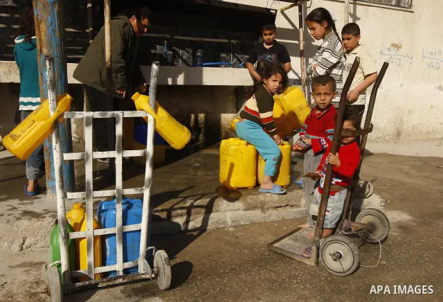 Palestinians fill bottles with water from a public tap in the United Nations Relief and Works Agency (UNRWA) headquarters in Rafah refugee camp in the southern of Gaza strip on April 26, 2011. Photo by Abed Rahim Khatib