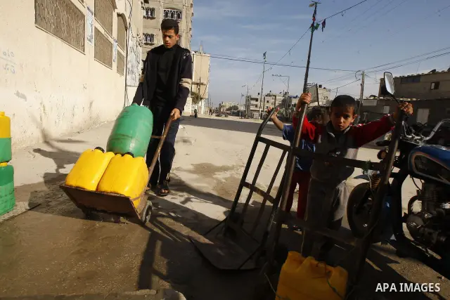 Palestinians fill bottles with water from a public tap in the United Nations Relief and Works Agency (UNRWA) headquarters in Rafah refugee camp in the southern of Gaza strip on April 26, 2011. Photo by Abed Rahim Khatib