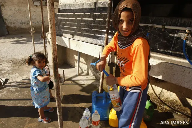 Palestinians fill bottles with water from a public tap in the United Nations Relief and Works Agency (UNRWA) headquarters in Rafah refugee camp in the southern of Gaza strip on April 26, 2011. Photo by Abed Rahim Khatib