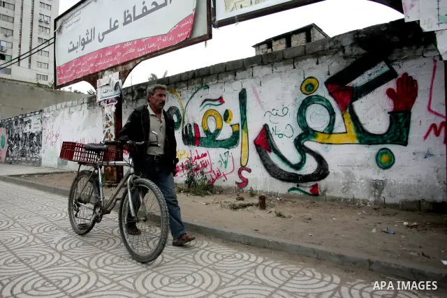 A Palestinian man walks past graffiti reading in Arabic, "Yes to the end of the division", in Gaza City on April 28, 2011 as Palestinians in the Gaza Strip and the West Bank welcomed reports that their rival Hamas and Fa...