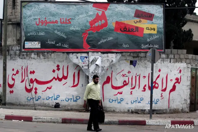 A Palestinian man walks past graffiti reading in Arabic, "Yes to the end of the division", in Gaza City on April 28, 2011 as Palestinians in the Gaza Strip and the West Bank welcomed reports that their rival Hamas and Fa...