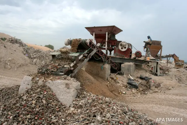 Palestinian workers smash large stones into small gravels to be used for building houses on April 28, 2011 in the southern Gaza Strip city of Khan Younis, as the coastal Palestinian territory continues to lack most const...