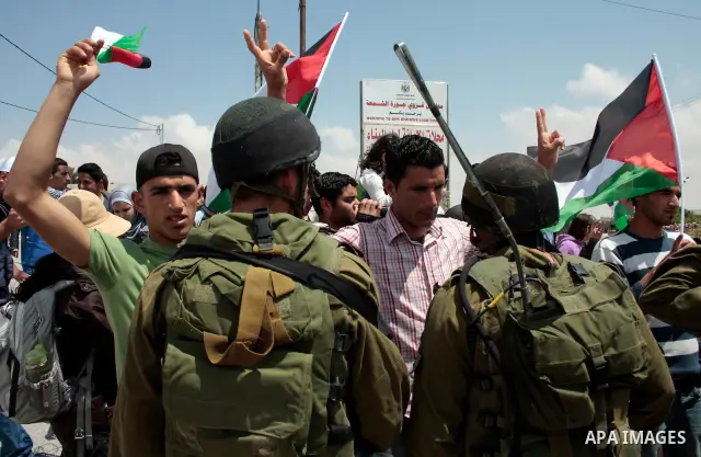Protesters argue with Israeli soldiers during a demonstration against Israel's controversial separation barrier in the West Bank village of Maasarah, near the biblical town of Bethlehem on April 29, 2011.Israel says the...