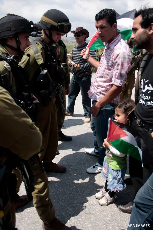 Protesters argue with Israeli soldiers during a demonstration against Israel's controversial separation barrier in the West Bank village of Maasarah, near the biblical town of Bethlehem on April 29, 2011.Israel says the...