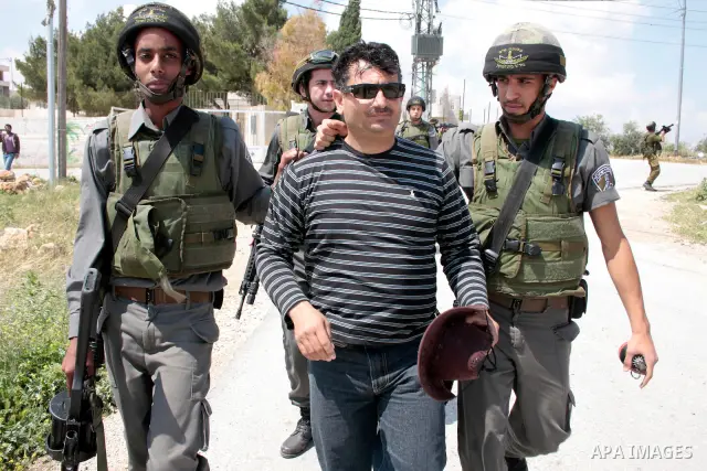 Israeli soldiers arrest a protester during a demonstration against Israel's controversial separation barrier in the West Bank village of Maasarah, near the West Bank town of Bethlehem on April 29, 2011.Israel says the ne...