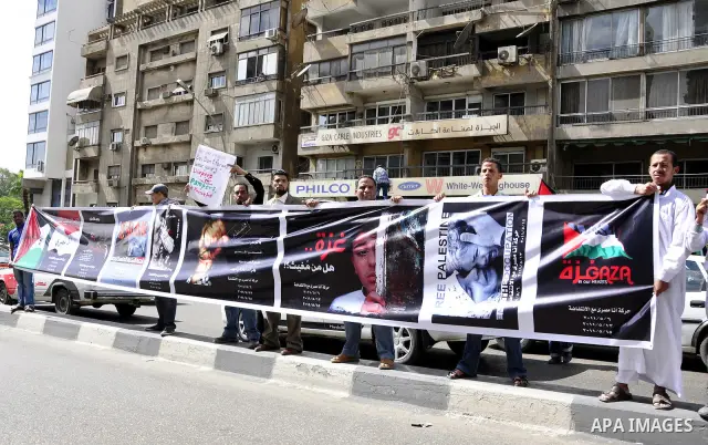 Egyptian protesters hold placards during a demonstration in front of the Israeli embassy in Cairo on April 29, 2011, calling for opening the border with the Gaza Strip and in support with Palestinian unity between Fatah...