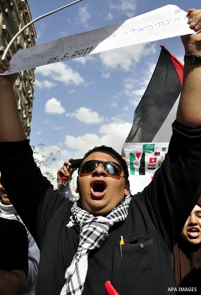 Egyptian protesters wave the Palestinian flag during a demonstration in front of the Israeli embassy in Cairo on April 29, 2011, calling for opening the border with the Gaza Strip and in support with Palestinian unity be...