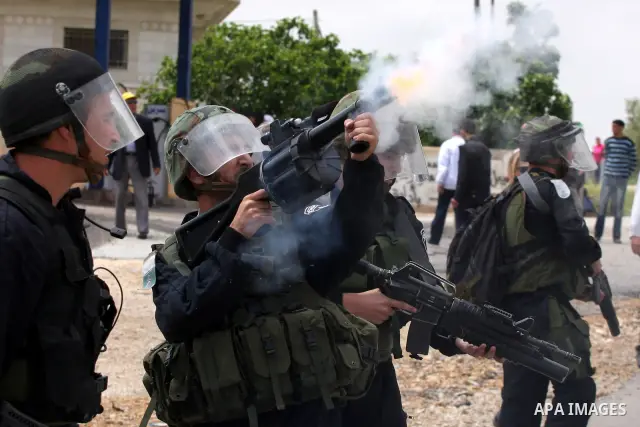 Israeli soldiers fire tear gas canisters toward demonstrators during protest against the expropriation of Palestinian land to expand the Jewish settlement of Halmish on April 29, 2011 in the West Bank village of Nabi Sal...