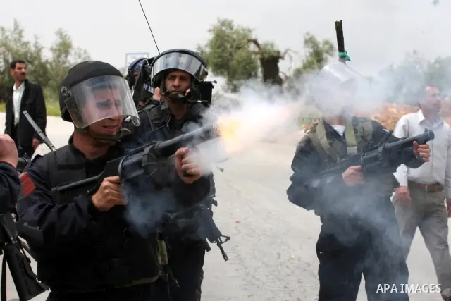Israeli soldiers fire tear gas canisters toward demonstrators during protest against the expropriation of Palestinian land to expand the Jewish settlement of Halmish on April 29, 2011 in the West Bank village of Nabi Sal...