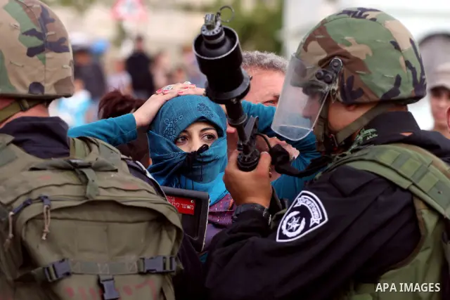 Demonstrator stand face-to-face with an Israeli soldiers during protest against the expropriation of Palestinian land to expand the Jewish settlement of Halmish on April 29, 2011 in the West Bank village of Nabi Saleh.....