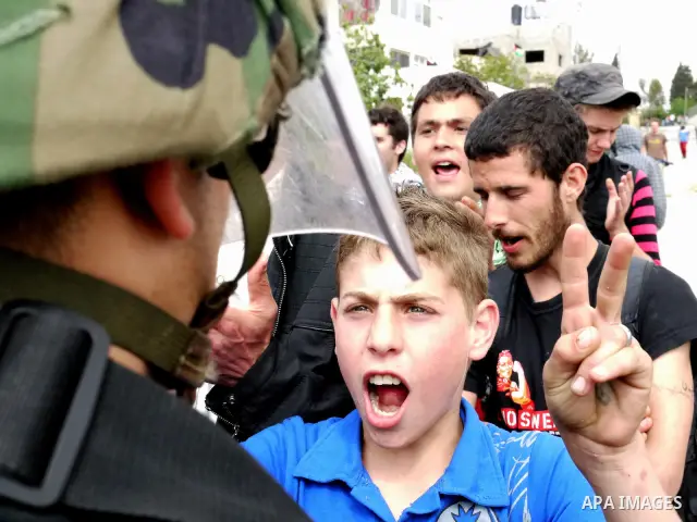 Demonstrator stand face-to-face with an Israeli soldiers during protest against the expropriation of Palestinian land to expand the Jewish settlement of Halmish on April 29, 2011 in the West Bank village of Nabi Saleh.....