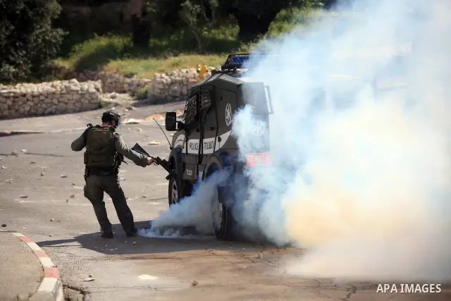 An Israeli soldier fires tear gas canisters towards Palestinian youths during clashes in the flashpoint east Jerusalem neighbourhood of Silwan on April 29, 2010.. Photo by Sliman Khader