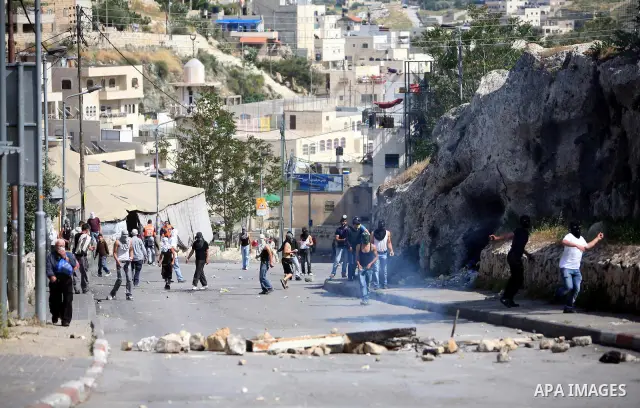 Palestinian youths hurl stones toward Israeli soldiers during clashes in the flashpoint east Jerusalem neighbourhood of Silwan on April 29, 2011.. Photo by Sliman Khader