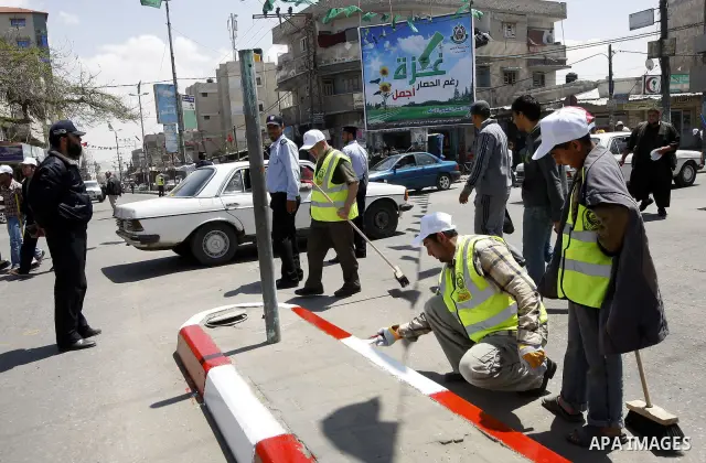 Members of the ruling Islamic Hamas movement paint the side walks as volunteers took to the street in a project entitled "Gaza is the most beautiful despite the blockade" to mark workers' May Day in Rafah town In Gaza St...
