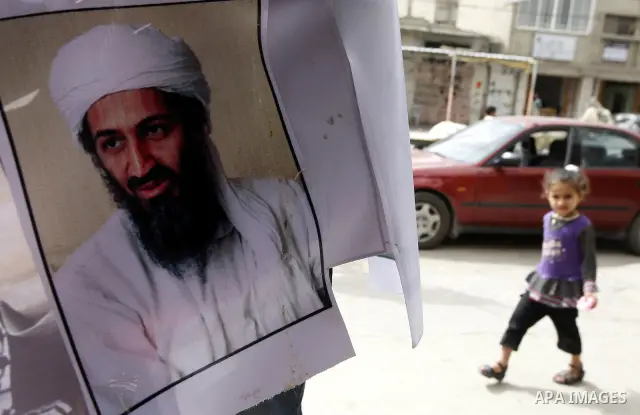 Palestinians walk past a poster of Osama bin Laden, in the southern Gaza Strip town of Rafah on May 2, 2011. The United States has killed Al-Qaeda leader Osama bin Laden nearly 10 years after the September 11, 2001 attac...