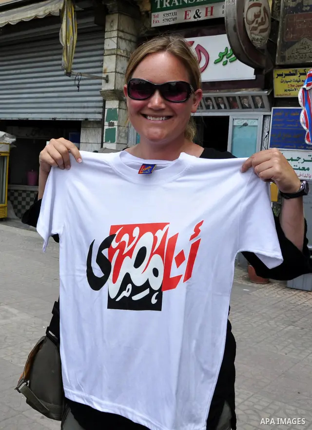 Foreign tourists buy T-shirts paint with an Egyptian flag and Arabic language words from a stall in Cairo, Egypt on May 3, 2011. Photo by Ahmed Asad
